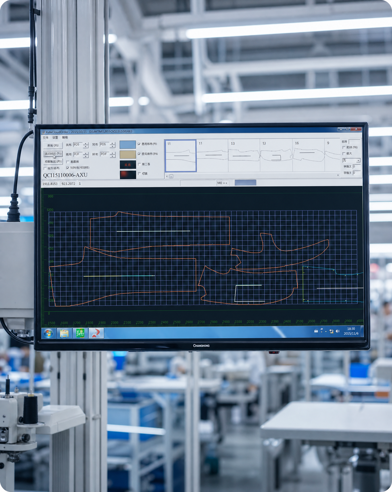 An overhead control screen on the factory floor displaying a CAD pattern layout for a garment