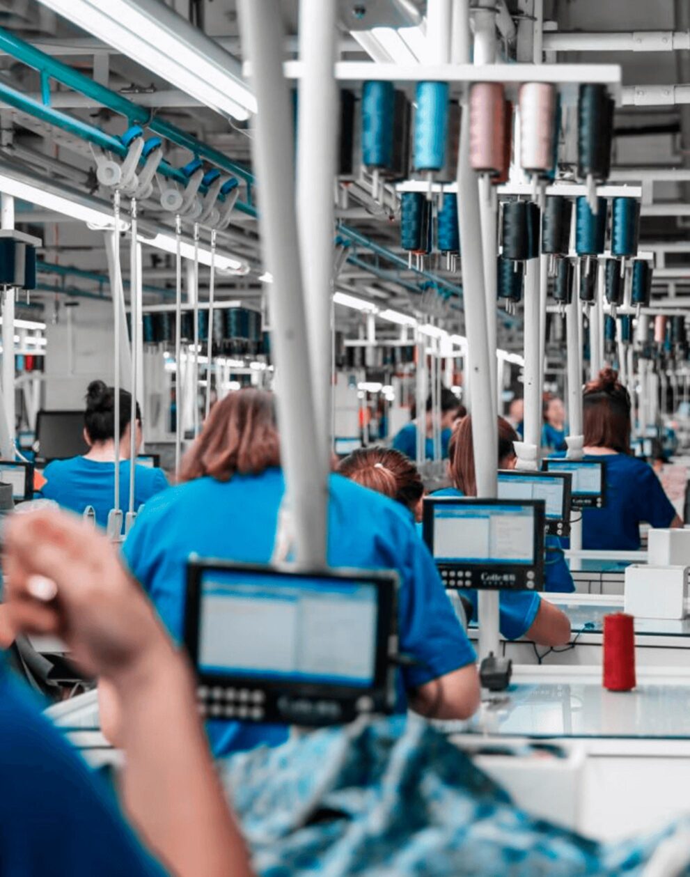 Inside a large apparel factory — long sewing line with workers and equipment